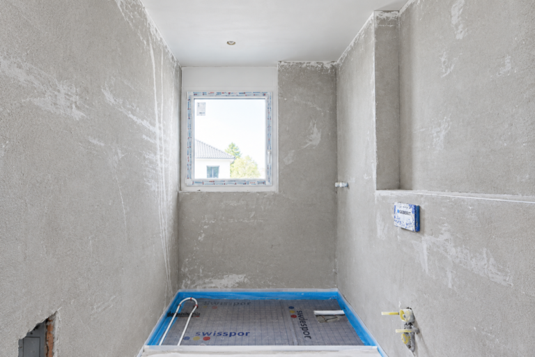 Unfertigtes Zimmer mit Fenster und Installationen